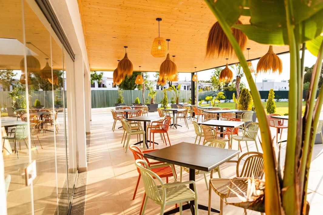 Esplanada do Bambino Pool Club com luminárias de ráfia ao pôr do sol